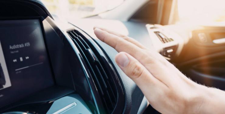 Hand checking the air conditioner in the car